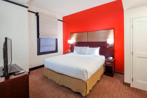 a hotel room with a large bed and a flat screen tv at Residence Inn by Marriott Omaha Downtown Old Market Area in Omaha