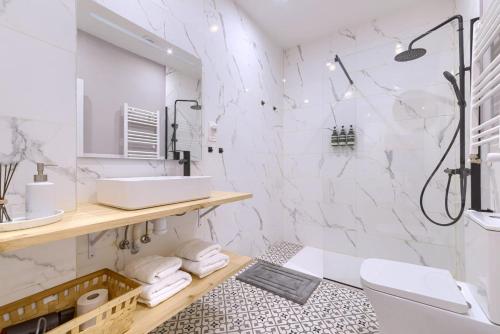 Un baño blanco con lavabo y ducha. en Roomscapital, en Bilbao