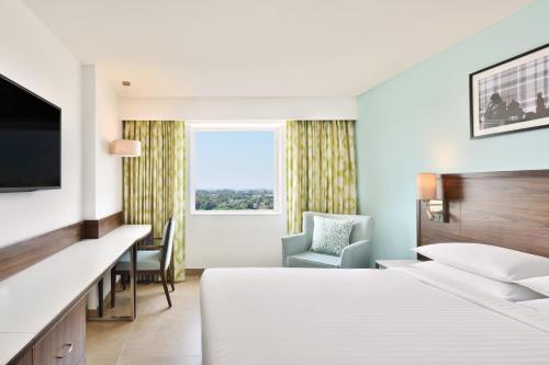 een hotelkamer met een bed en een bureau bij Fairfield by Marriott Chennai OMR in Chennai