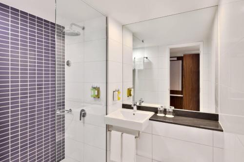 Baño blanco con lavabo y espejo en Fairfield by Marriott Chennai OMR, en Chennai