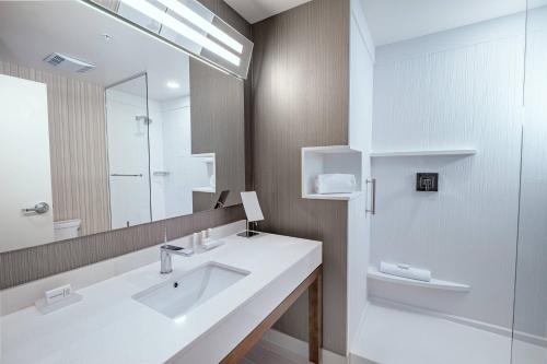 a bathroom with a white sink and a mirror at Courtyard by Marriott Toledo West in Toledo