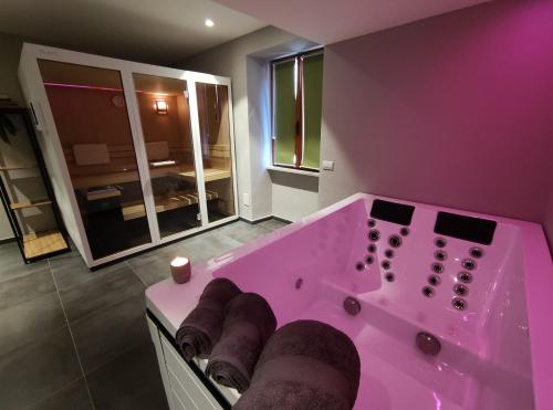 W łazience znajduje się różowa wanna z dużym lustrem. w obiekcie Hotel Bed & Bike Ledro w mieście Molina di Ledro