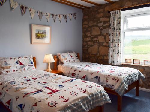 a bedroom with two beds and a window at Sea Breeze Cottage in Staithes