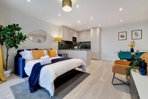 a bedroom with a large bed and a kitchen at Luxury Harrow Wembley Apartment in Harrow