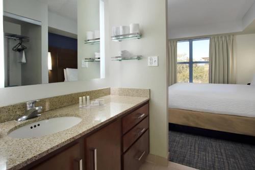 La salle de bains est pourvue d'un lavabo et d'un lit dans la chambre. dans l'établissement Residence Inn Scottsdale North, à Scottsdale