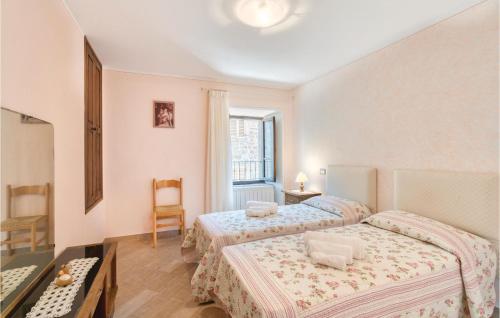 a bedroom with two beds and a table and a chair at Antico Seccatoio in Chitignano