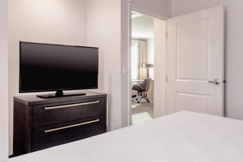 a bedroom with a flat screen tv on a dresser at Residence Inn by Marriott Loma Linda Redlands in Redlands