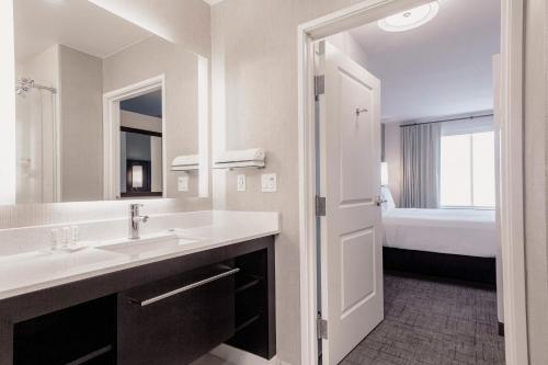 a white bathroom with a sink and a bed at Residence Inn by Marriott Loma Linda Redlands in Redlands