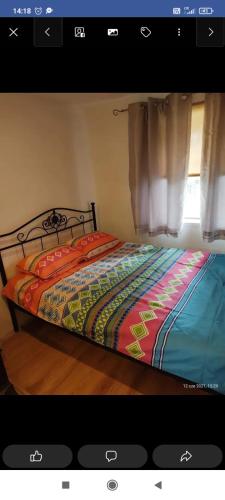 1 dormitorio con 1 cama con un edredón colorido en Domek nad jeziorem en Ryn