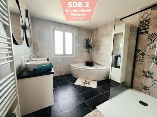 a bathroom with a tub and a toilet and a sink at Maison au calme à 5min de Cognac pour 1 à 8 pers in Richemont