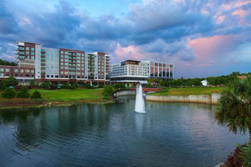 a fountain in the middle of a lake with buildings at AC Hotel by Marriott Tallahassee Universities at the Capitol in Tallahassee