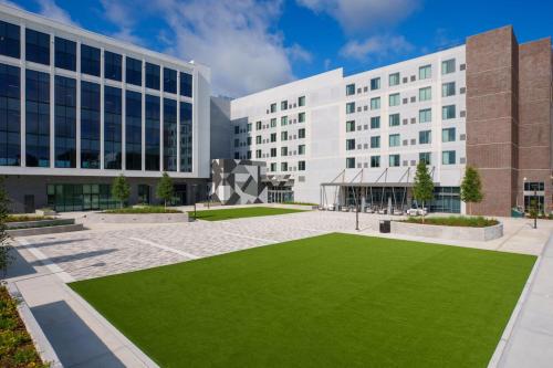 a rendering of the exterior of a building with a green lawn at AC Hotel by Marriott Tallahassee Universities at the Capitol in Tallahassee