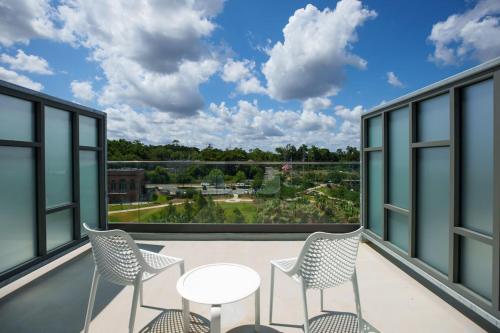 a balcony with chairs and a table with a view at AC Hotel by Marriott Tallahassee Universities at the Capitol in Tallahassee