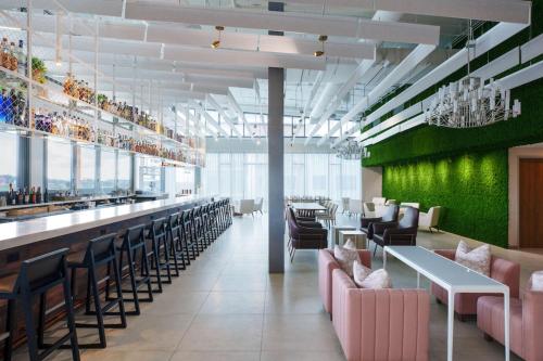 a restaurant with pink chairs and a green wall at AC Hotel by Marriott Tallahassee Universities at the Capitol in Tallahassee