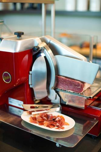 a red mixer on a table with a plate of food at AC Hotel by Marriott Tallahassee Universities at the Capitol in Tallahassee