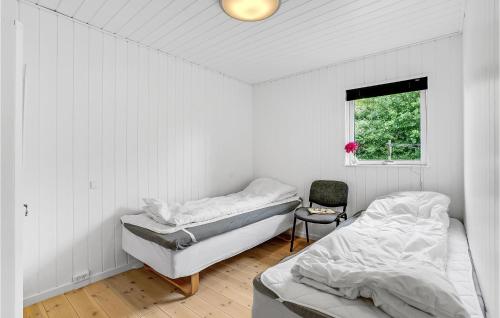 Amazing Home In Vggerlse With 5 Bedrooms, Sauna And Wifi في Bøtø By: سريرين في غرفة بيضاء مع نافذة
