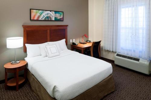 a hotel room with a large bed and a desk at TownePlace Suites Suffolk Chesapeake in Suffolk