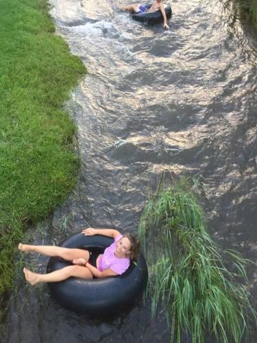 a girl laying on an inner tube in the water at The Big tree @ Sabie in Sabie