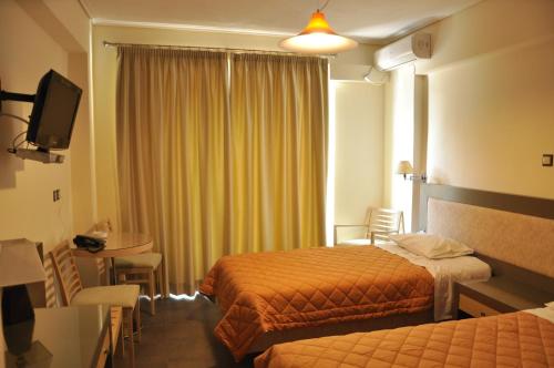Habitación de hotel con 2 camas y mesa en Philoxenia, en Thiva