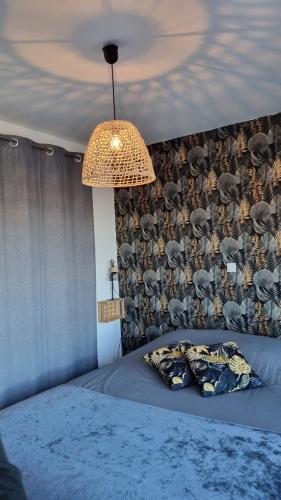 a bedroom with a bed with a wall covered in elephants at L'Honna Flow, appartement de charme près du centre. in Honfleur