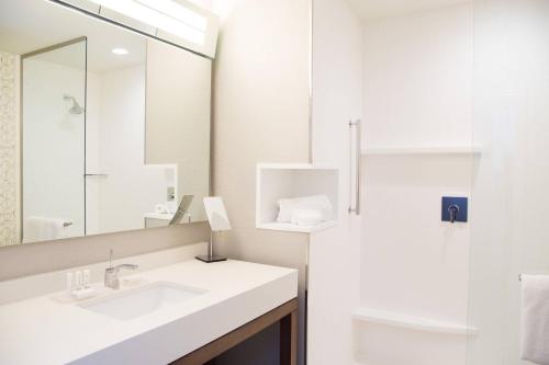 Baño blanco con lavabo y espejo en Courtyard by Marriott Oxford en Oxford