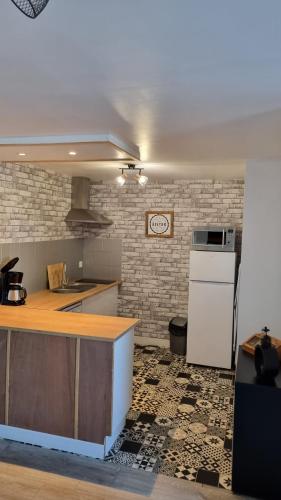 Il comprend une cuisine équipée d'un comptoir et d'un réfrigérateur blanc. dans l'établissement L'Honna Flow, appartement de charme près du centre., à Honfleur