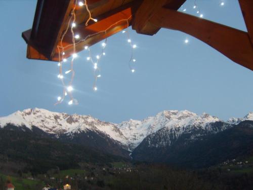 a view of snow covered mountains with christmas lights at Gite Au Coeur Du Chalet en Belledonne vers Prapoutel Les 7 Laux in Sainte-Agnès