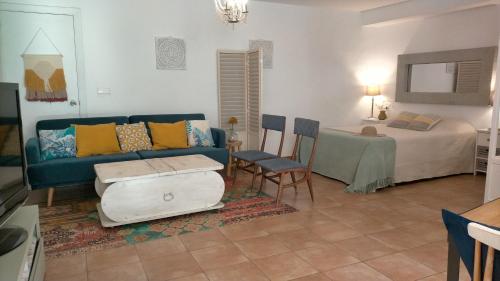 トレモリノスにあるLovely Andalusian Loft in torremolinosのリビングルーム(青いソファ、ベッド付)