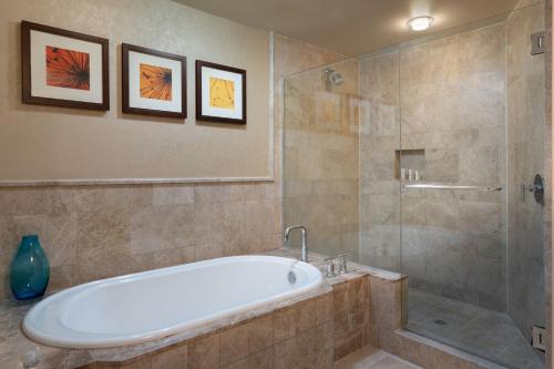 a bathroom with a tub and a glass shower at Palm Beach Marriott Singer Island Beach Resort & Spa in Palm Beach Shores