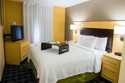 um quarto de hotel com uma cama e uma televisão em MainStay Suites Houston NASA-Clear Lake em Webster