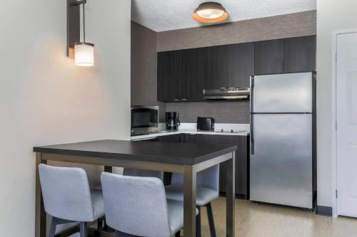 a kitchen with a black table and a refrigerator at Residence Inn Boulder Longmont in Longmont