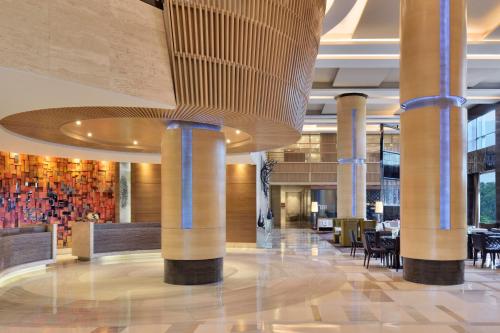 昌迪加爾的住宿－JW萬豪昌迪加爾酒店，大堂设有桌椅和天花板。
