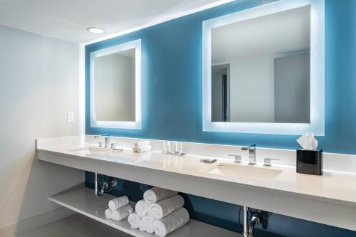 a bathroom with two sinks and two mirrors at Marriott Sanibel Harbour Resort & Spa in Fort Myers