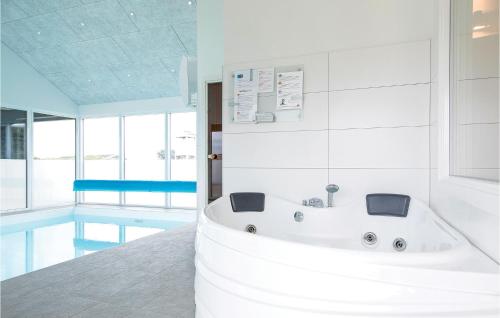 uma casa de banho com uma banheira e uma piscina em Stunning Home In Lkken With Outdoor Swimming Pool em Løkken