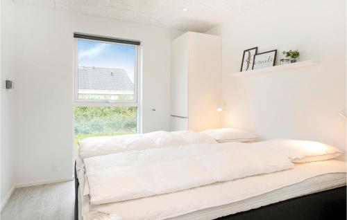 ロッケンにあるStunning Home In Lkken With Outdoor Swimming Poolの白いベッドルーム(ベッド1台、窓付)