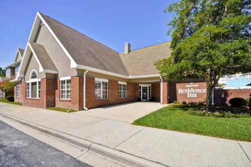 a red brick building with a sign that reads the residence inn at Residence Inn by Marriott Jacksonville Airport in Jacksonville