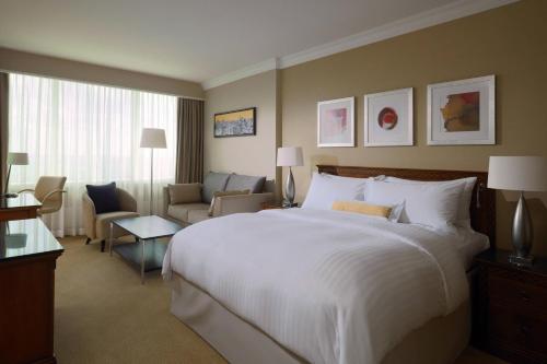 una habitación de hotel con una cama grande y una silla en Warsaw Marriott Hotel, en Varsovia