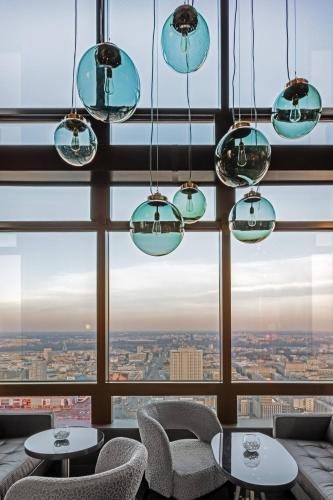 a room with a large window with chairs and tables at Warsaw Presidential Hotel in Warsaw