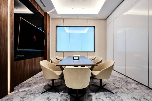 a conference room with a table and chairs and a screen at Warsaw Presidential Hotel in Warsaw