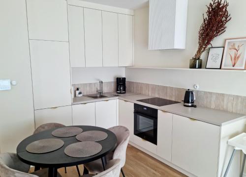 a kitchen with a table and chairs in a kitchen at Apartament Lublin Centrum "Angora Cat" in Lublin
