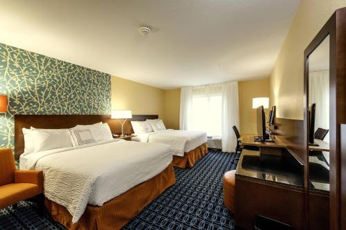 a hotel room with two beds and a flat screen tv at Fairfield Inn & Suites by Marriott Meridian in Meridian