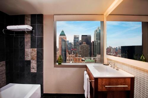 een badkamer met een raam met uitzicht op de stad bij The Westin New York at Times Square in New York