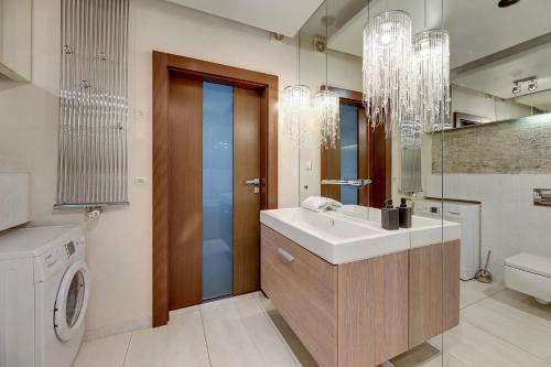 een badkamer met een wastafel en een wasmachine bij Willa Morska Deluxe by Grand Apartments in Sopot