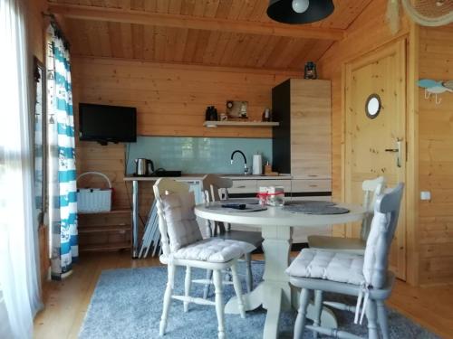 eine Küche mit einem Tisch und Stühlen in einer Hütte in der Unterkunft Domek letniskowy SZUWAREK in Świnoujście