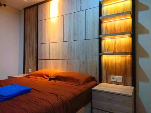 sypialnia z łóżkiem i drewnianą ścianą w obiekcie Borneo Bay City Apartment Balikpapan w mieście Klandasan Kecil