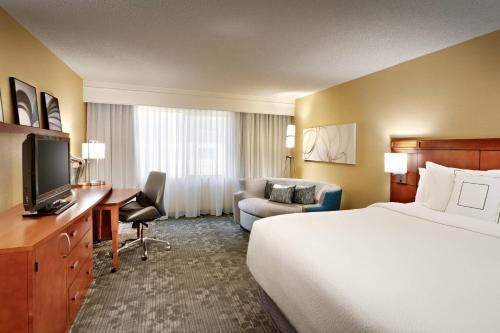 a hotel room with a bed and a television at Courtyard by Marriott Salt Lake City Sandy in Sandy