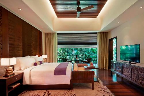 a bedroom with a large bed and a television at Mulu Marriott Resort in Mulu