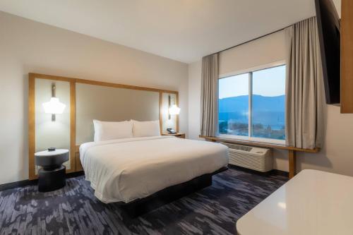 a hotel room with a bed and a large window at Fairfield Inn & Suites by Marriott Salmon Arm in Salmon Arm