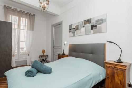 ein Schlafzimmer mit einem Bett mit einem blauen Kissen darauf in der Unterkunft Acacia magnifique T2 rénové. in Montauban