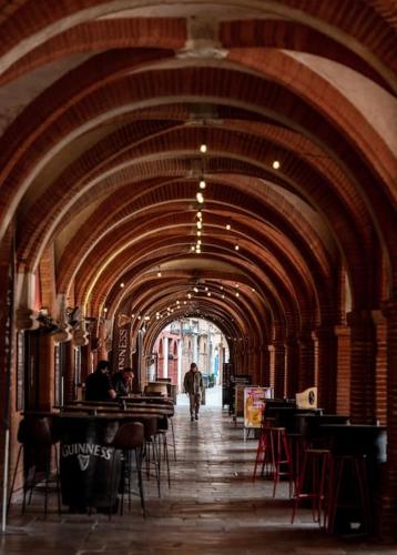 un couloir avec des tables et des chaises dans un bâtiment dans l'établissement Acacia magnifique T2 rénové., à Montauban